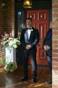 Man in tuxedo speaking at a wedding ceremony at Anchor and Hope.