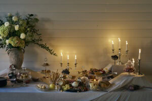 Elegant dessert table with candles and floral arrangement at a celebration.