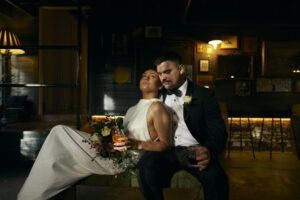 Elegant wedding couple enjoying a romantic moment in a cozy bar setting.